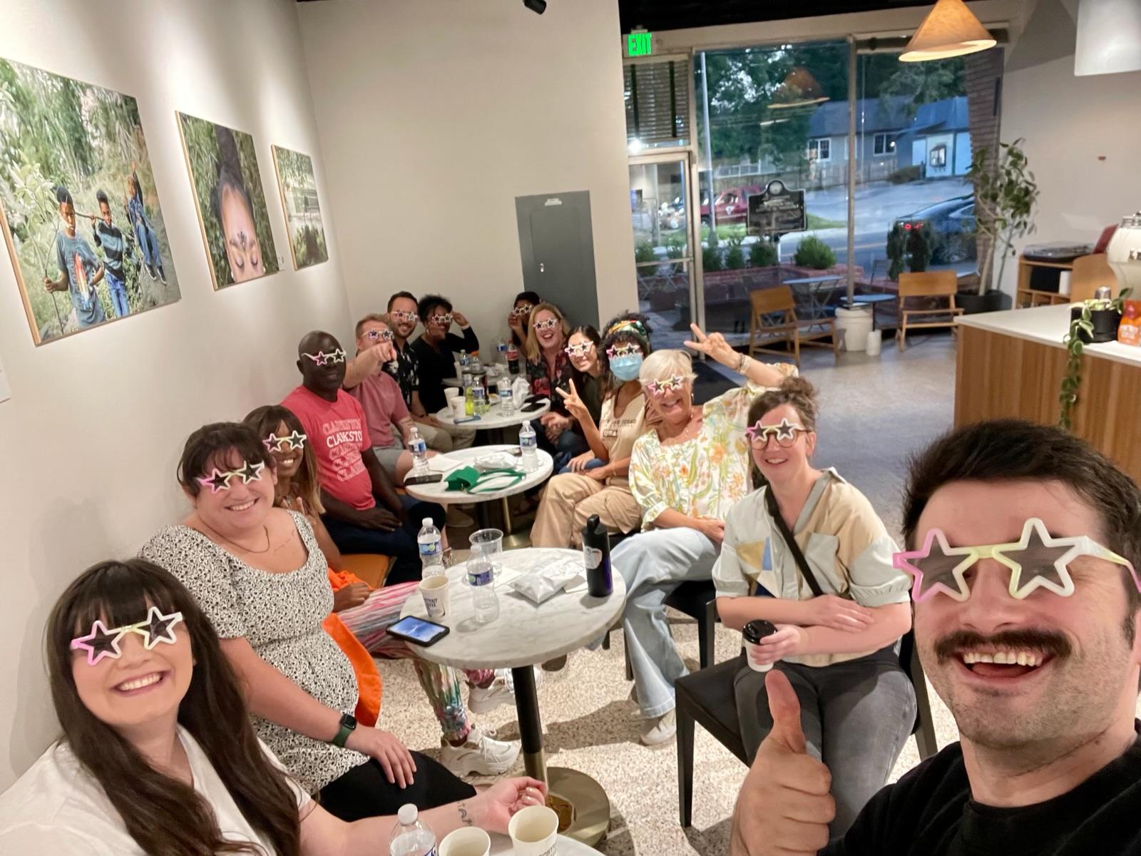 The Refuge Crew with star glasses on around tables